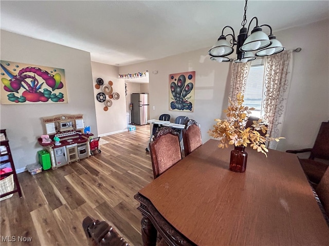 dining space featuring hardwood / wood-style floors and a notable chandelier