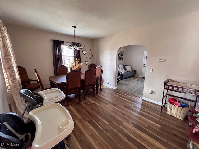 dining room with a notable chandelier and dark hardwood / wood-style flooring