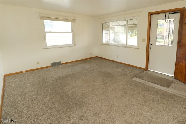 carpeted spare room featuring a healthy amount of sunlight