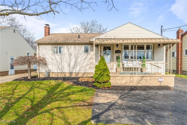 view of front of house featuring covered porch and a front yard