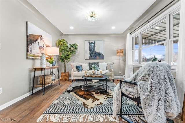 sitting room with hardwood / wood-style floors and a baseboard heating unit