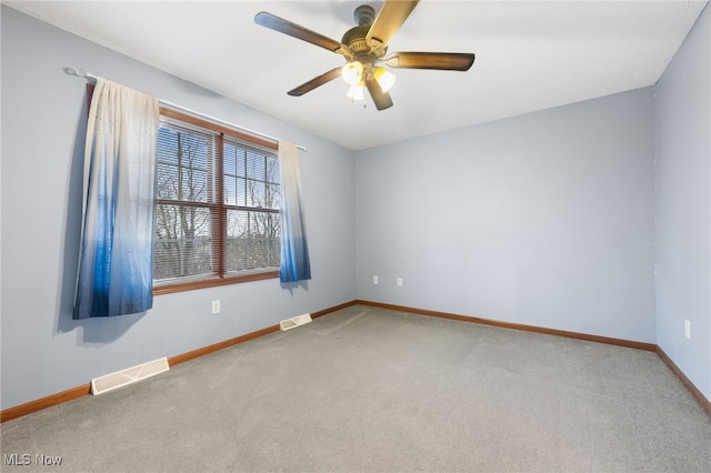 spare room with ceiling fan and light carpet