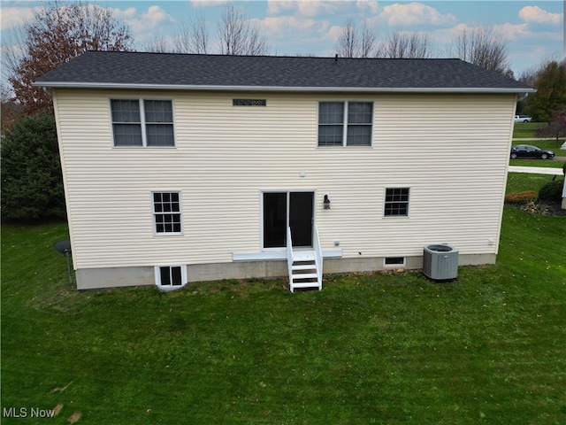 rear view of house featuring a yard and central air condition unit