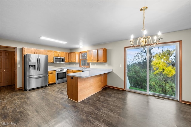 kitchen featuring dark wood-type flooring, hanging light fixtures, a notable chandelier, kitchen peninsula, and stainless steel appliances