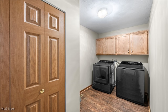 washroom featuring dark hardwood / wood-style floors, cabinets, and independent washer and dryer