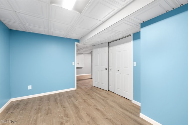 unfurnished bedroom with light wood-type flooring and a closet