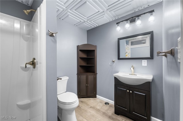 bathroom with walk in shower, hardwood / wood-style floors, vanity, and toilet