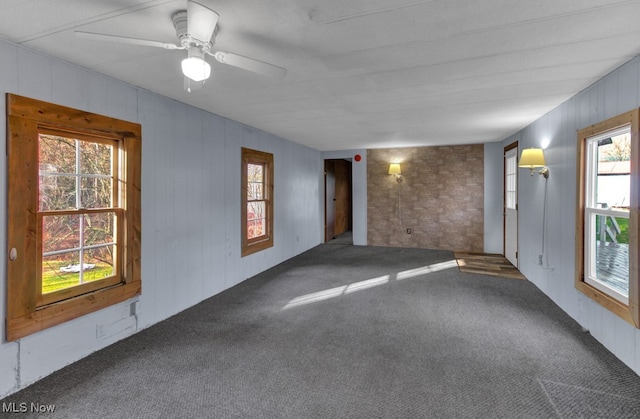 unfurnished room featuring carpet floors, plenty of natural light, and ceiling fan