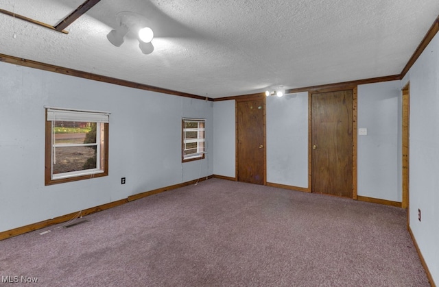 carpeted empty room with a textured ceiling and crown molding