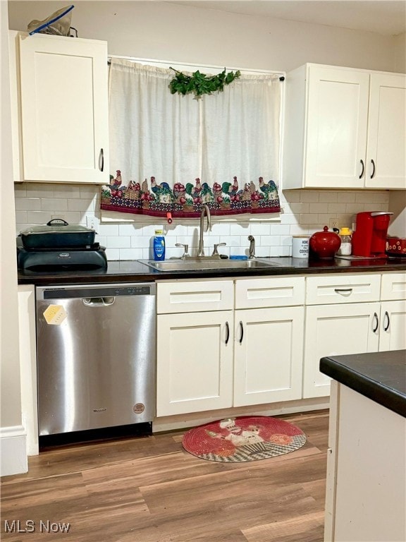 kitchen featuring white cabinetry, sink, tasteful backsplash, light hardwood / wood-style flooring, and stainless steel dishwasher