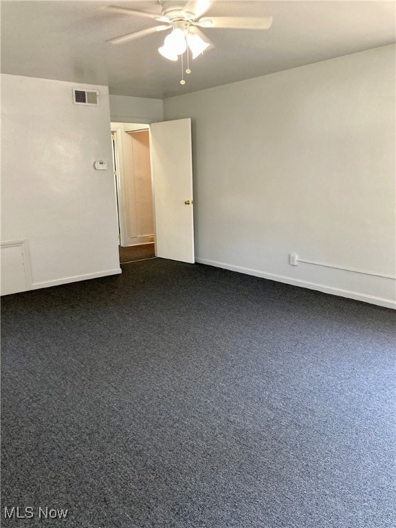 empty room featuring dark carpet and ceiling fan