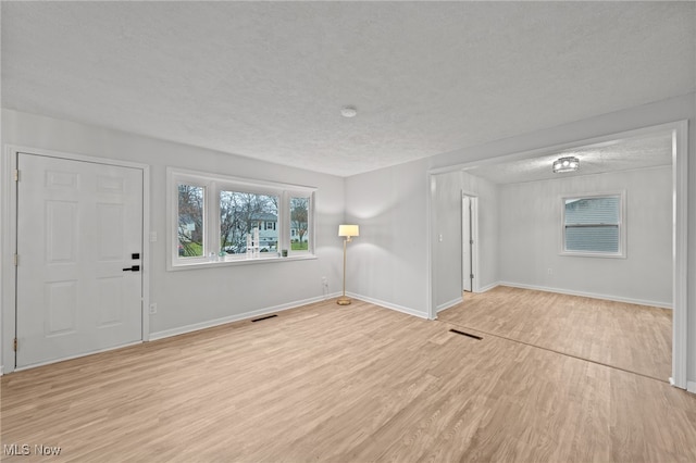 entryway featuring a textured ceiling and light wood-type flooring