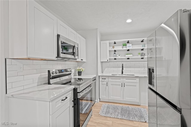 kitchen with sink, white cabinetry, and stainless steel appliances