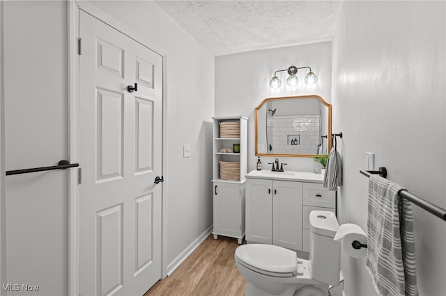 bathroom featuring hardwood / wood-style floors, vanity, a textured ceiling, and toilet