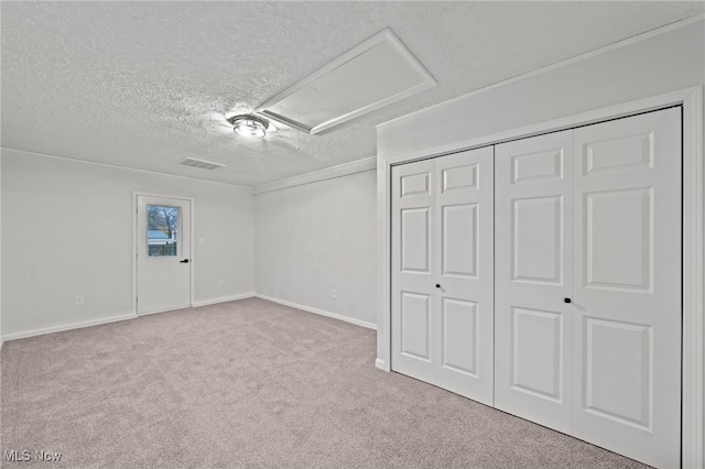 unfurnished bedroom featuring light carpet and a textured ceiling