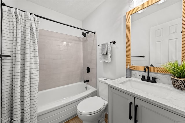 full bathroom with vanity, shower / bath combination with curtain, a textured ceiling, and toilet