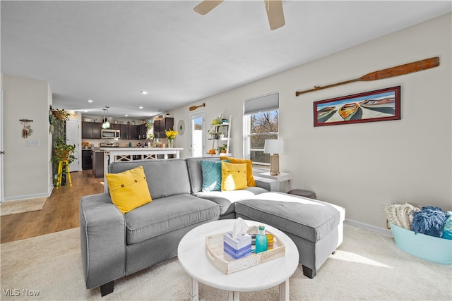 living room with wood-type flooring and ceiling fan