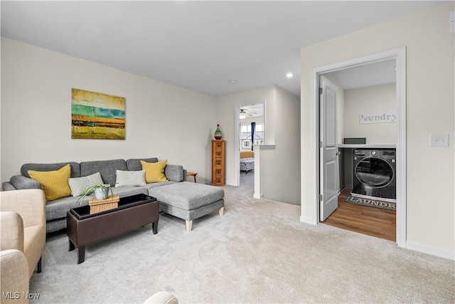 living room featuring washer / clothes dryer and light carpet