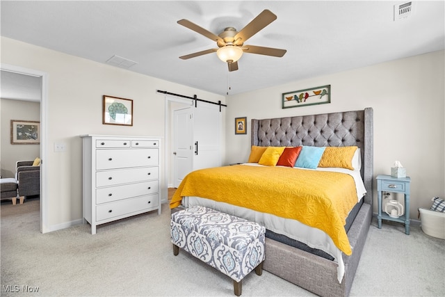 bedroom featuring a barn door, ceiling fan, and light carpet