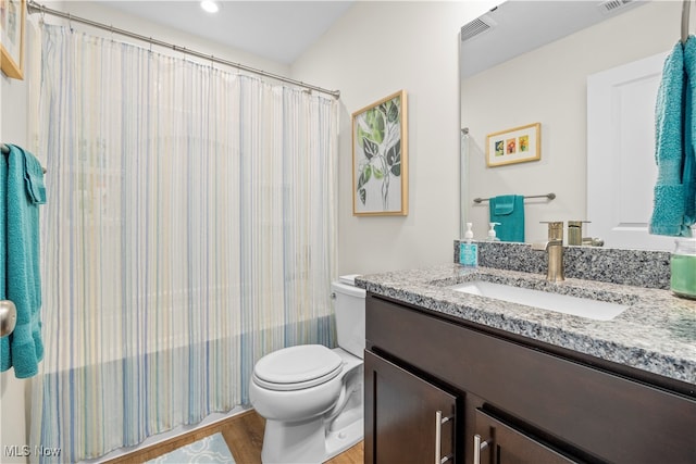 full bathroom with vanity, toilet, wood-type flooring, and shower / tub combo