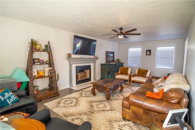 living room with wood-type flooring, a textured ceiling, and ceiling fan