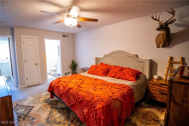 bedroom with carpet, ensuite bathroom, ceiling fan, and a textured ceiling