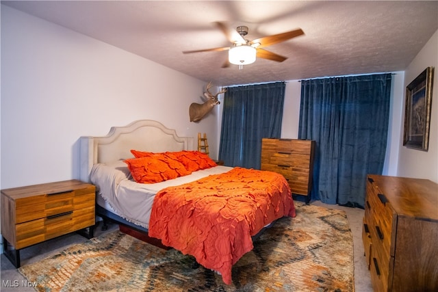 bedroom featuring ceiling fan, carpet, and a textured ceiling