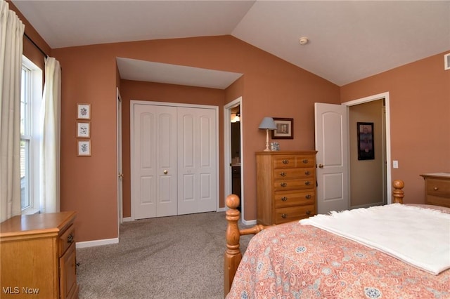 bedroom featuring light colored carpet, vaulted ceiling, and a closet