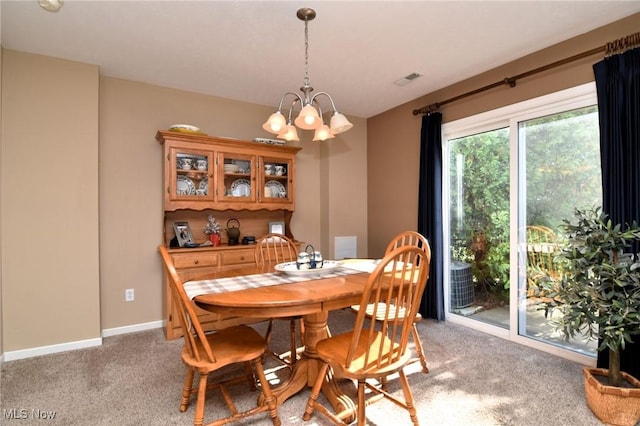 carpeted dining space with a notable chandelier