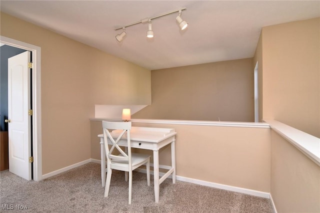 carpeted office space featuring rail lighting