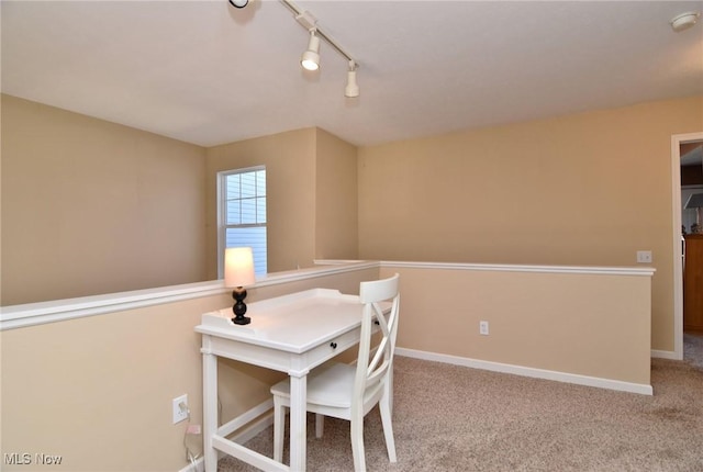 carpeted dining space with rail lighting