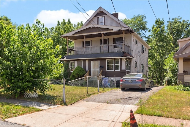 view of front of property featuring a front yard and a balcony