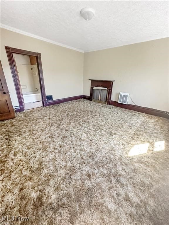 carpeted empty room with crown molding and a textured ceiling