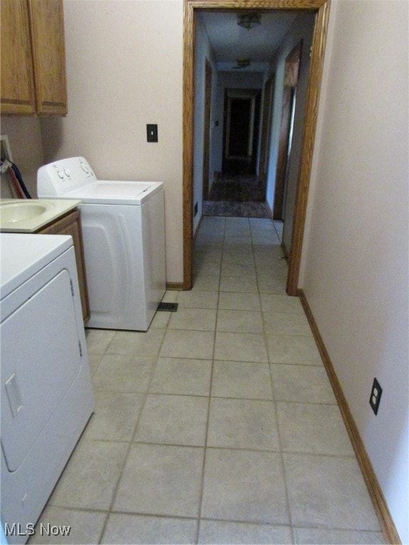 laundry room featuring light tile patterned flooring, cabinets, and independent washer and dryer