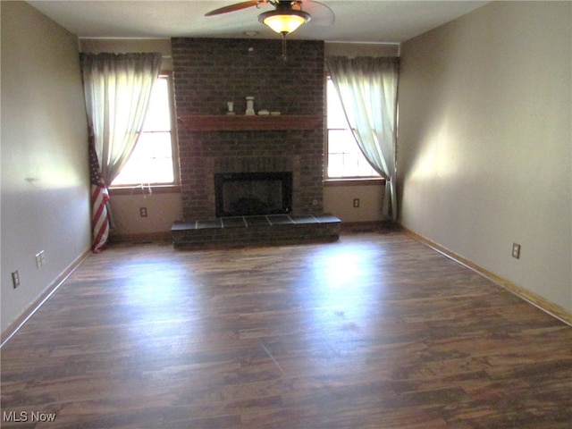 unfurnished living room with dark hardwood / wood-style flooring, ceiling fan, and a healthy amount of sunlight