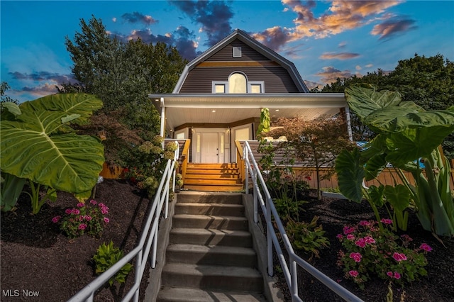 exterior entry at dusk featuring a porch