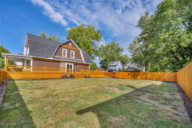 back of property with a deck and a lawn