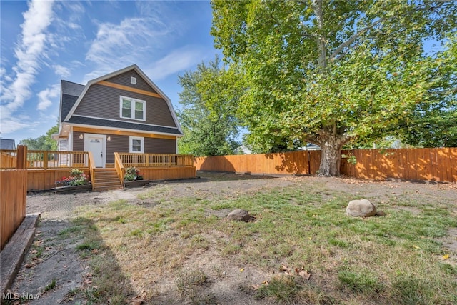 back of house featuring a yard and a wooden deck