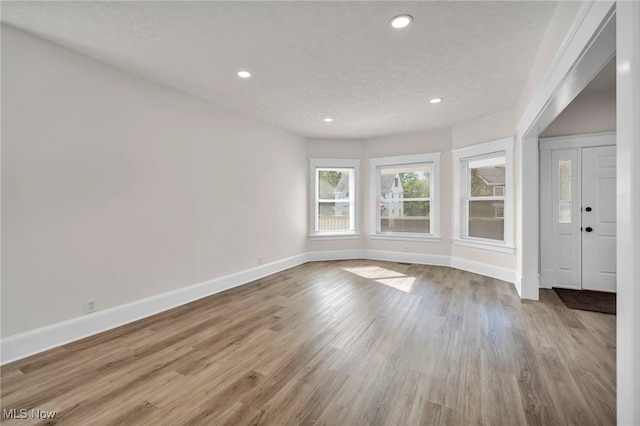 interior space with a textured ceiling and light wood-type flooring