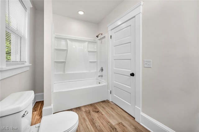 bathroom with wood-type flooring, toilet, and shower / washtub combination