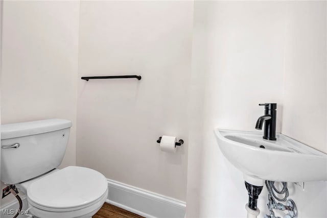 bathroom with hardwood / wood-style flooring, toilet, and sink