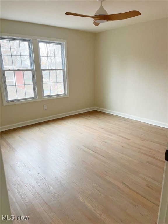 empty room with ceiling fan and light hardwood / wood-style flooring