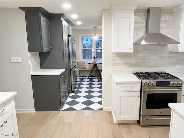 kitchen with white cabinets, wall chimney exhaust hood, decorative backsplash, and stainless steel appliances