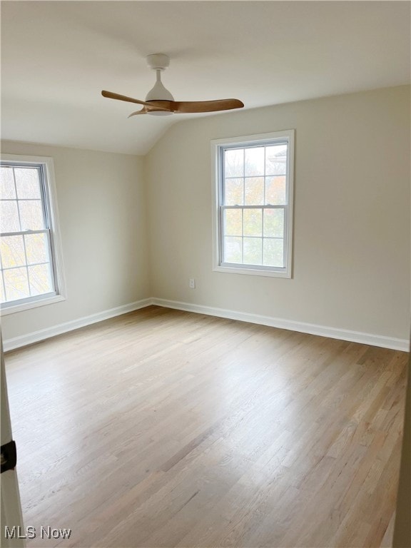 unfurnished room with light hardwood / wood-style floors, vaulted ceiling, plenty of natural light, and ceiling fan