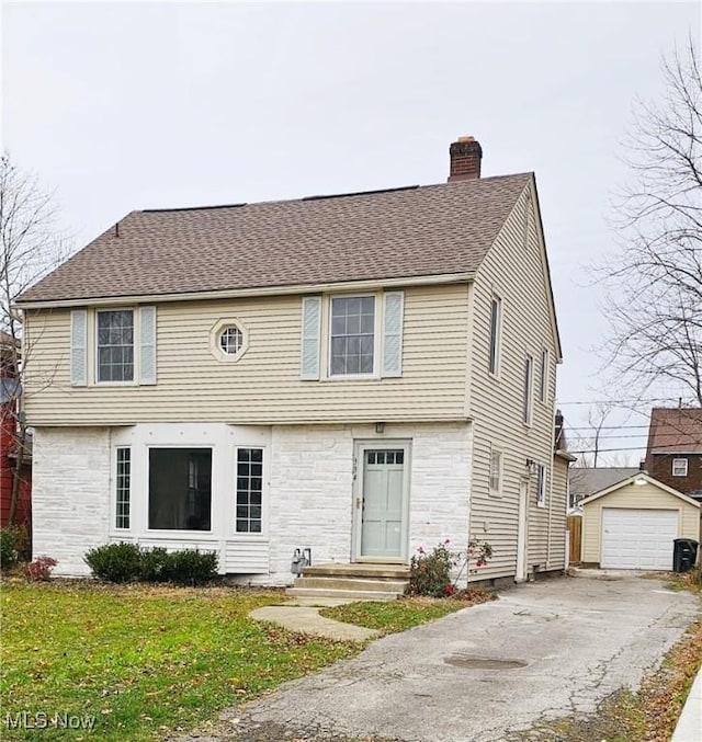 view of front of home with an outbuilding, a garage, and a front yard