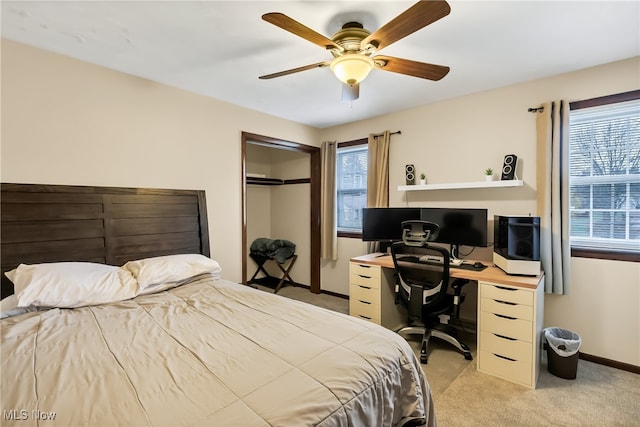 bedroom featuring multiple windows, ceiling fan, a closet, and light colored carpet