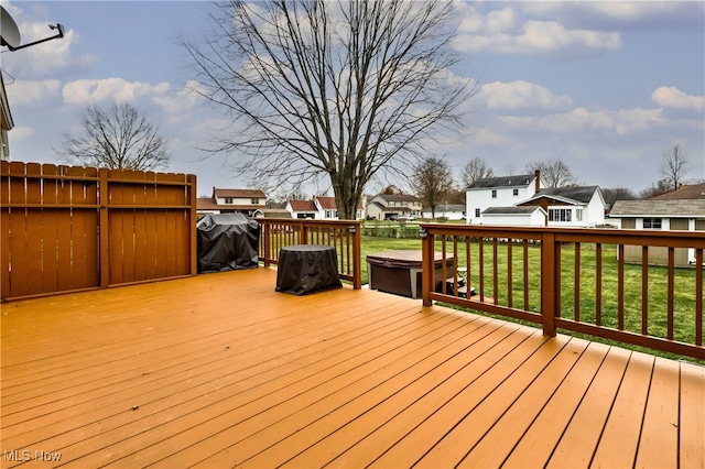 wooden deck featuring a yard and a grill