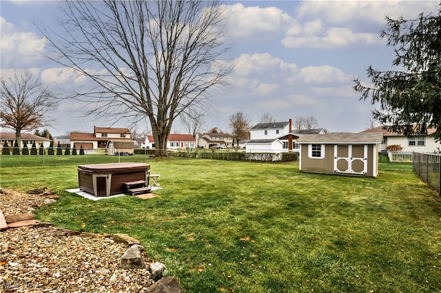 view of yard featuring a shed and a hot tub