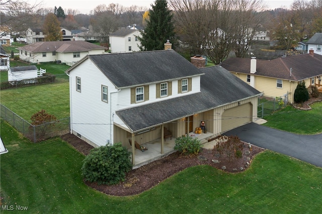 exterior space with a garage, covered porch, and a front yard