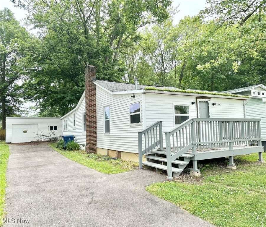 view of front of property with a wooden deck, an outbuilding, and a garage